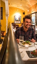 Couple laughing whilst dining at restaurant