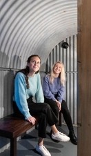 Two women sitting in a replica shelter in the Imperial War Museums, London