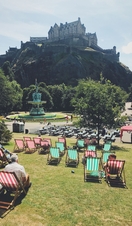 Green and red deck chairs laid out on grass in a park