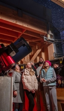 A family stand with a tour guide at an Observatory
