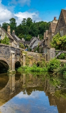 Blue skies and reflections in the picturesque Cotswold village of Castle Combe.