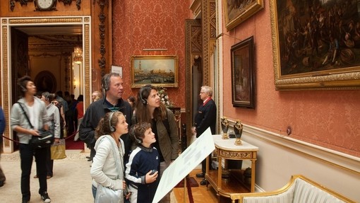 Eine Familie betrachtet die Gemälde an der Wand des Buckingham Palace bei der Sommereröffnung 2011