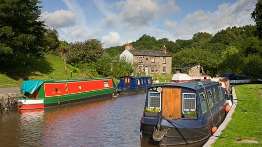 Narrowboats moored on a canal surrounded by grassy land