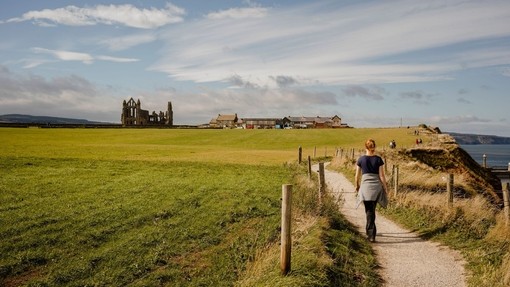 Woman walking along path between Whitby and Robin Hood's Bay.