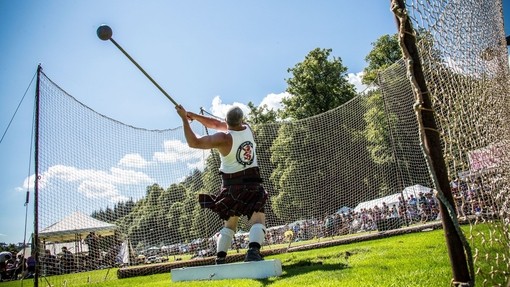 Mann im Kilt beim Hammerwurf bei den Inveraray Argyll Highland Games, Inveraray Castle, Schottland
