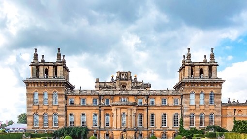 Woman walking in Blenheim Palace gardens surrounded by greenery