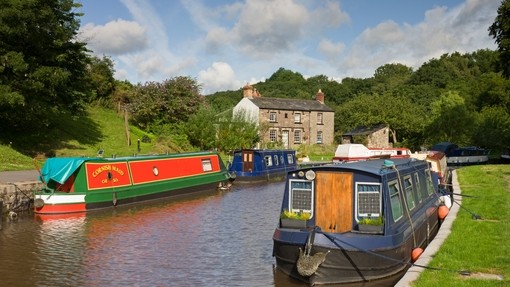 Narrowboats moored on a canal surrounded by grassy land