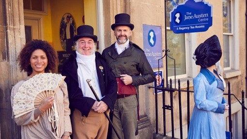 Visitors and staff in period costume outside The Jane Austen Centre, Bath, Somerset, England