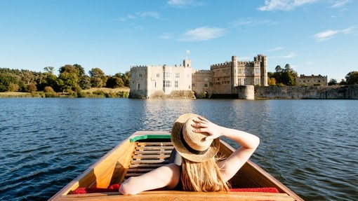 Woman in a punt on the moat looking towards castle
