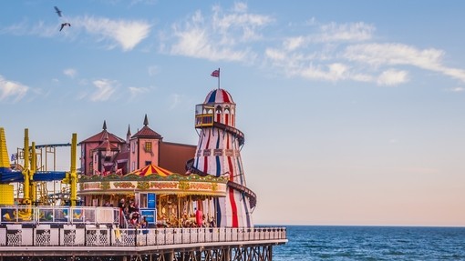 Jetski in sea below a seaside pier with a funfair