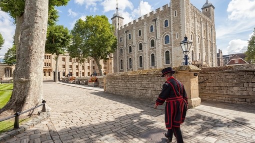 Beefeater walking by the, Tower of London on a sunny day
