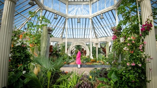 A visitor enjoys Surreal Pillars of Mexico, a horticultural display by Jon Wheatley at Kew Gardens