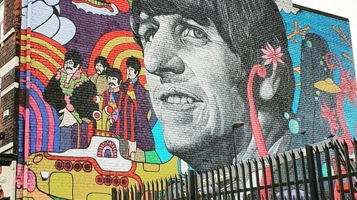Grafitti art of the Beatles, prominently featuring George Harrison, on a wall in Liverpool