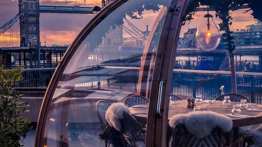 Wooden table under a glass dome with view of London skyline