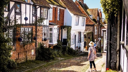 Woman looking down a narrow village street between houses