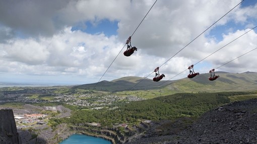 Personas utilizando tirolinas sobre Penrhyn Quarry, cerca de Snowdonia, Gales
