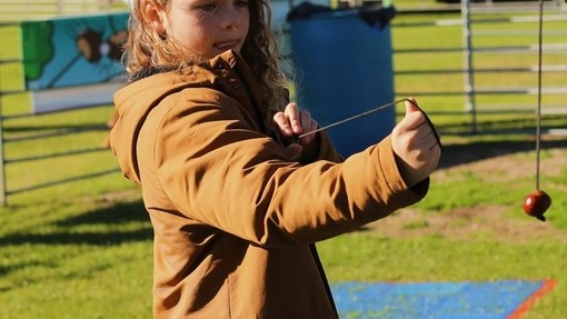 Ein Kind spielt mit einer Kastanie bei den World Conker Championships in Northamptonshire