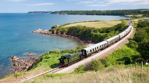 Dampfzug auf einer Bahnstrecke entlang der Küste