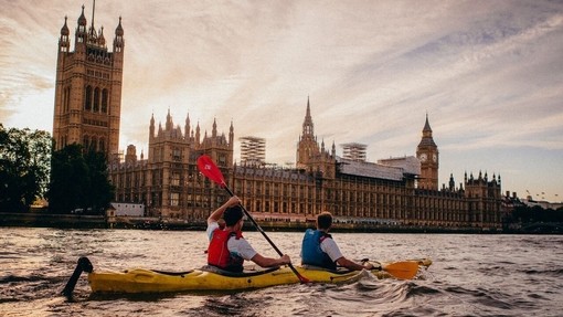 People kayaking on river Thames going past Big Ben and the Houses of Parliament