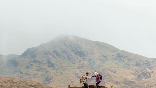 Couple hiking in the mountains on a cloudy day