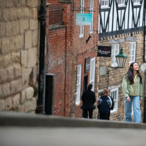 A woman and a man walk up a steep hill in a heritage City