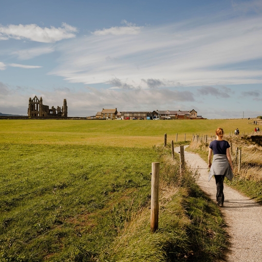 Woman walking along path between Whitby and Robin Hood's Bay.