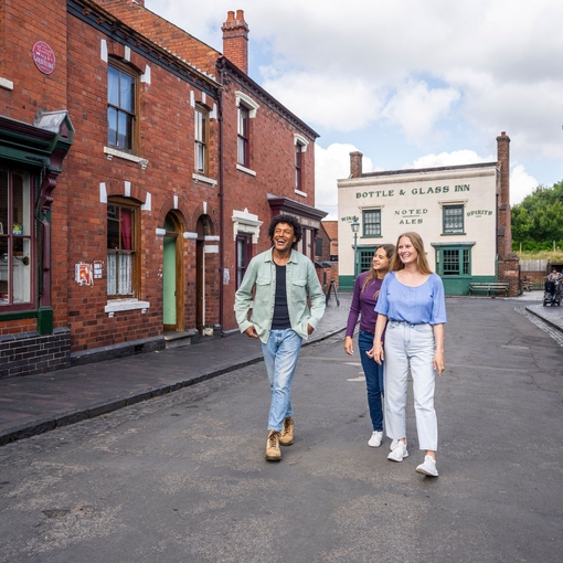 three friends explore the streets of a period living museum.