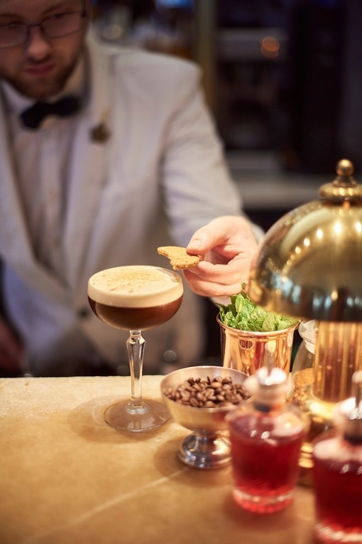 Bartender putting shortbread on espresso martini