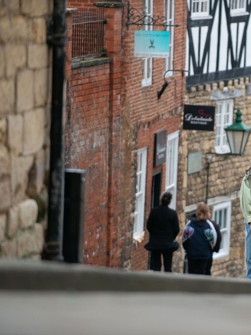 A woman and a man walk up a steep hill in a heritage City
