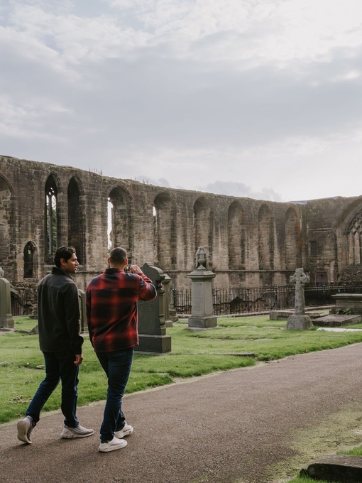 Two men walking by an Abbey Nave.
