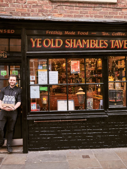 Hombre de pie frente a la taberna Ye Old Shambles
