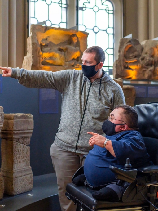 Two people looking at artefacts in a museum exhibit. 