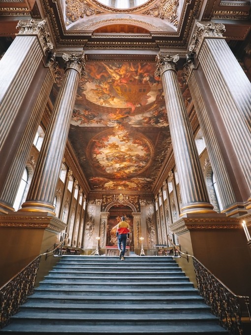Man walking up a staircase. Painted night sky on ceiling