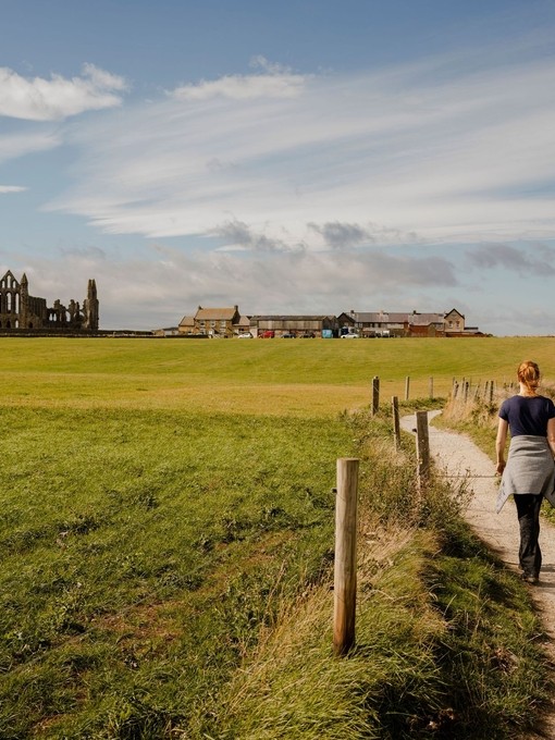 Woman walking along path between Whitby and Robin Hood's Bay.