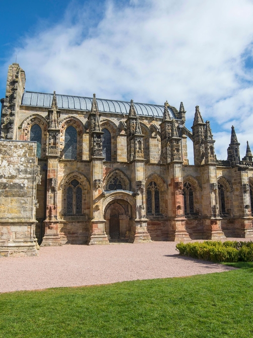 Exterior view of the remains of a Medieval chapel on a sunny day. 