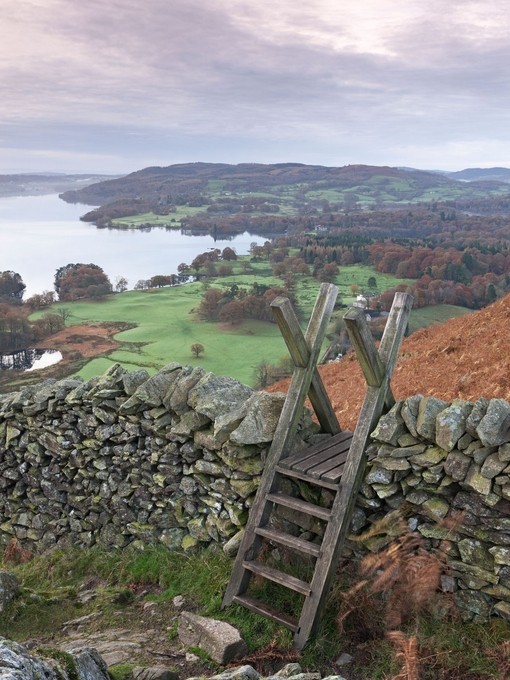 Stile over a drystone wall overlooking landscape of valleys