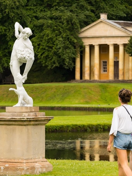A young couple walking through the grounds of Fountains Abbey and Studley Royal Water Garden, North Yorkshire