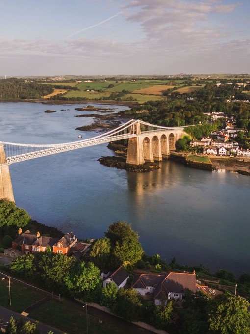 Landscape view of a suspension bridge over a river.