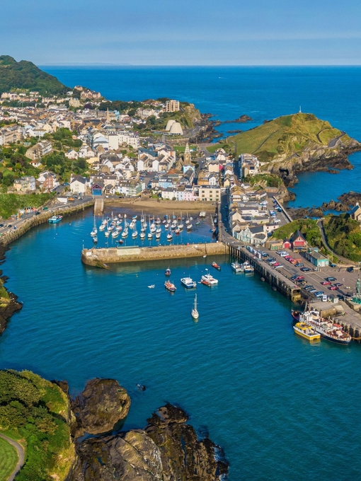 Aerial view of a coastal town with a harbour filled with boats