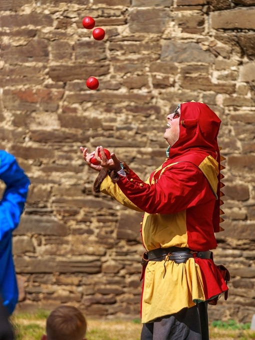 Jongleur en costume jonglant avec des balles à Castell Coch au Pays de Galles