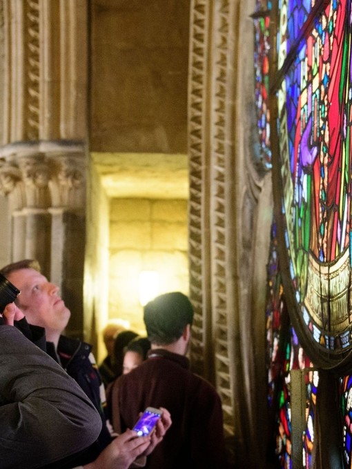 Un gruppo in visita alla Cattedrale di Lincoln, mentre osserva una vetrata colorata