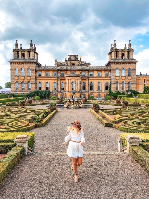 Woman walking in Blenheim Palace gardens surrounded by greenery