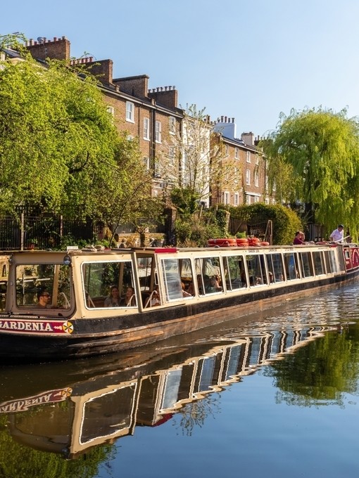 A canal boat moving down Regent's Canal in north London.