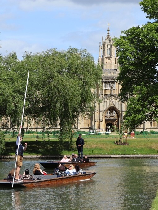 A punting tour passing a historic university building in Cambridge