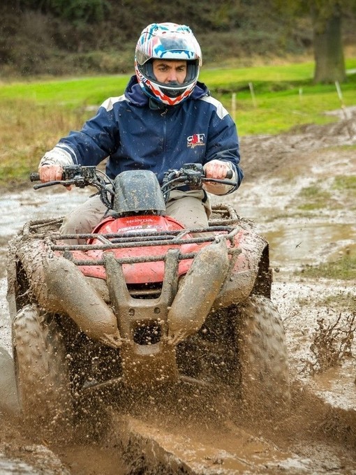 A man riding a quad bike on a muddy track near Stratford-upon-Avon