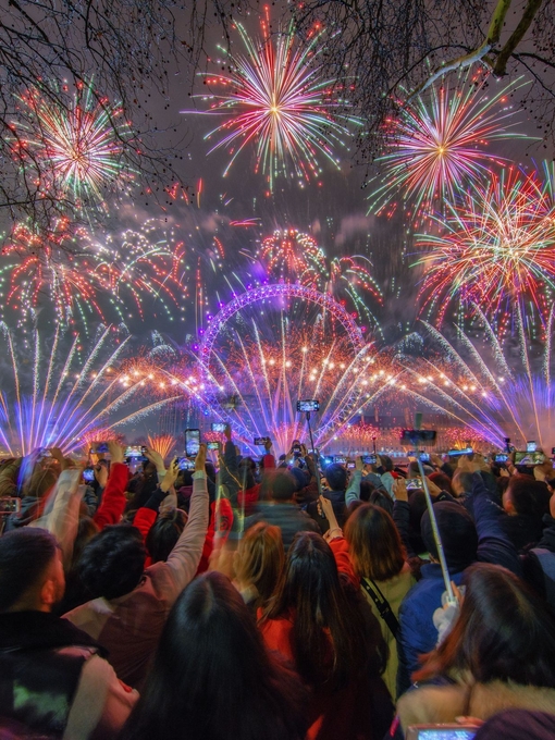 A crowd watching fireworks celebrating New Year's Eve