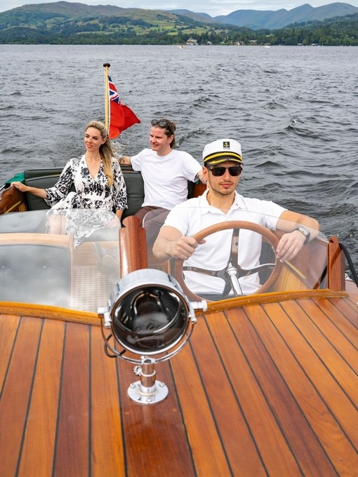 A man and a woman on a boat driven by a skipper on a lake