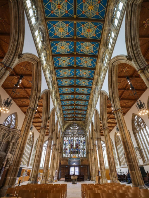 Looking up inside to the intricate ornate ceiling of an old church.