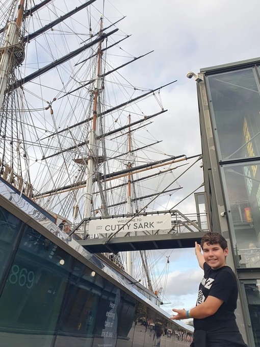 A child posing outside the Cutty Sark in Greenwich, London