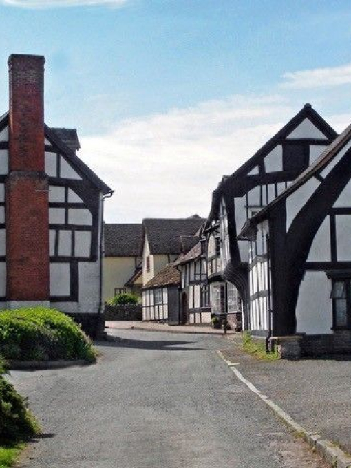 View of street lined with black and white timber framed cottages